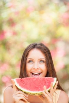 Portrait of a beautiful young woman eating watermelon