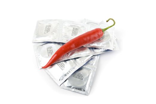Red peppers on a condom packs over  white background

