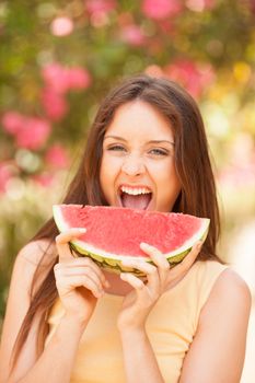 Portrait of a beautiful young woman eating watermelon