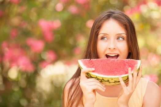 Portrait of a beautiful young woman eating watermelon