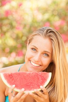 Portrait of a beautiful young woman eating watermelon