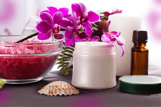 Beauty spa settings with orchids, oil and cream