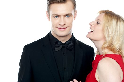 Woman whispering something to her sweetheart on white background