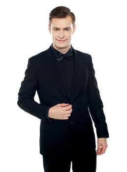 Smiling young man in party wear attire. Undoing coat button