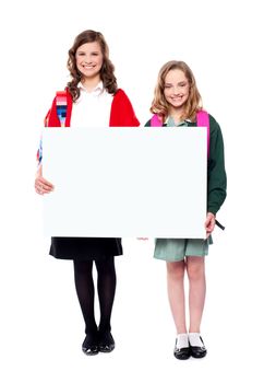 Schoolgirls holding big blank banner ad and smiling at camera