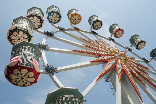 Bottom up view of Ferris wheel against blue sky in a park