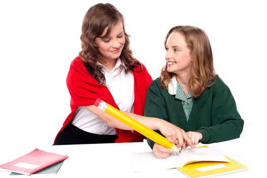 Girl explaining solution to her friend and helping her resolve question