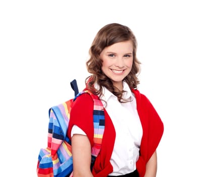 Smiling teenager student with colorful bag on her shoulders