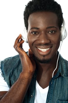 Young man listening to music through headphones, closeup shot