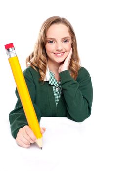 Young girl using an over sized pencil. Writing on surface
