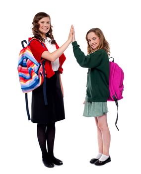 Students giving high five to each other and smiling. Full length portrait