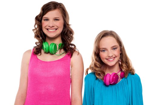 Teenagers posing with headphones around neck in front of camera