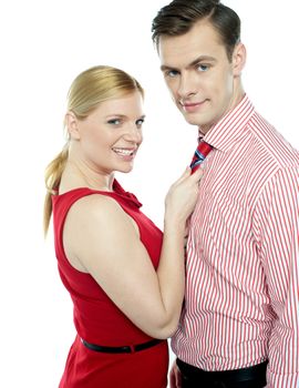 Girl in red holding businessman by his tie. Sensual shot