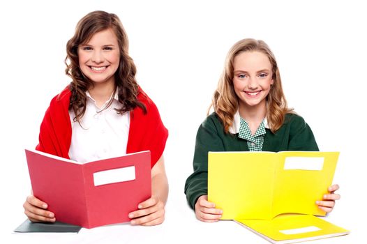 Smiling girl learning from school books isolated over white