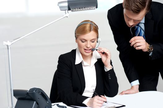 Woman discussing the problem with male colleague on papers document