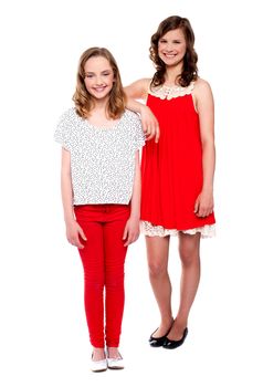 Two young girls posing on white background. Full length shot