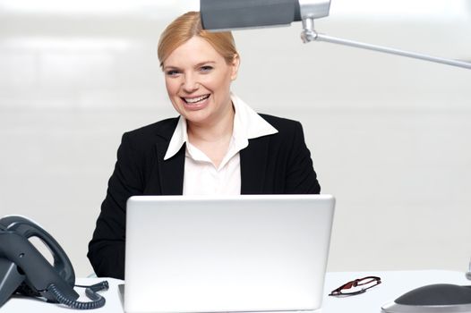 Pretty businesswoman at work. Operating laptop in office