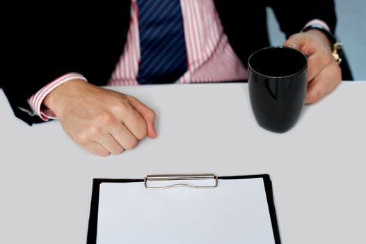 Closeup of businessman holding empty cup. Office desk. Closeup shot