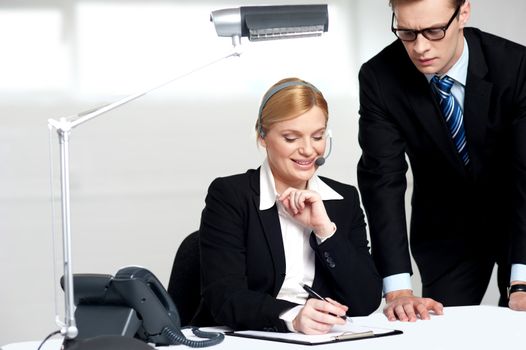 Young business people reading documents in the office and making corrections