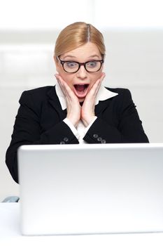 Surprised business woman after looking into laptop