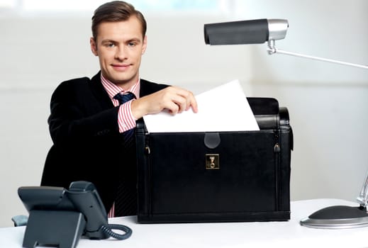 Male executive keeping documents safely in his briefcase