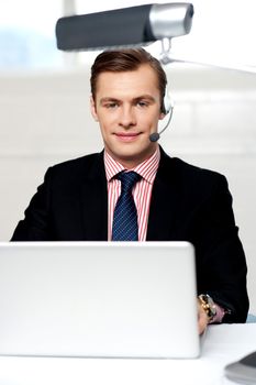 Portrait of handsome male operator wearing headset looking at camera