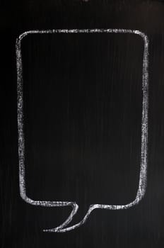 Blank speech bubble drawn with chalk on a smudged blackboard background for text writing and design