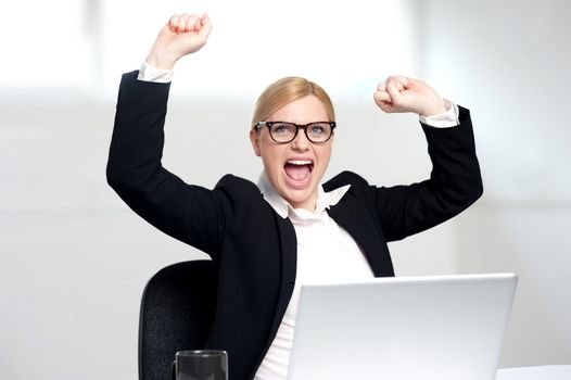 Excited young businesswoman completing looking upwards. Success portrait