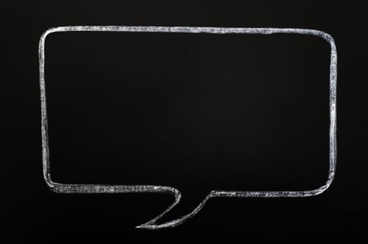 Blank speech bubble drawn with chalk on a smudged blackboard background for text writing and design