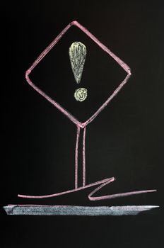 Exclamation mark warning sign drawn with red chalk on a blackboard background