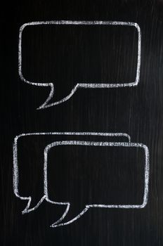 Chalk drawing of speech bubbles on a blackboard