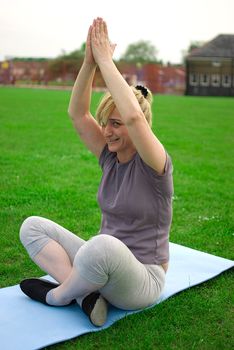 middle aged woman keeping fit with exercises in a park