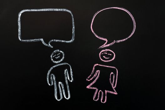 Chalk drawing of blank speech bubbles with human figures on a blackboard background