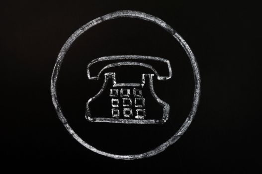 Old phone symbol drawn with chalk on a blackboard background