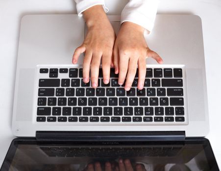 Kid hand on keypad of laptop at workplace