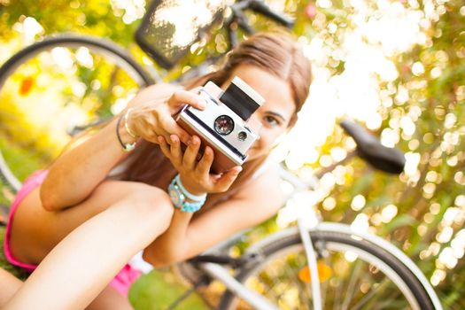 beautiful young woman playing with a vintage camera