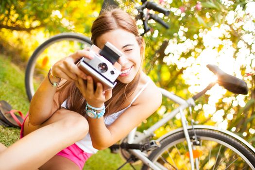 beautiful young woman playing with a vintage camera