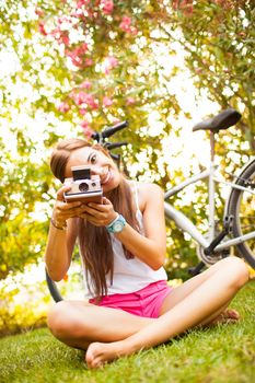 beautiful young woman playing with a vintage camera