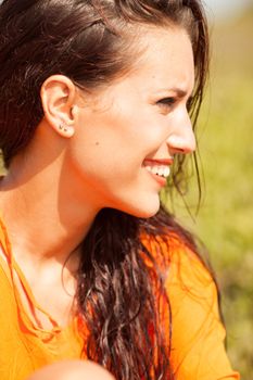 Portrait of young beautiful woman laughing wearing orange shirt