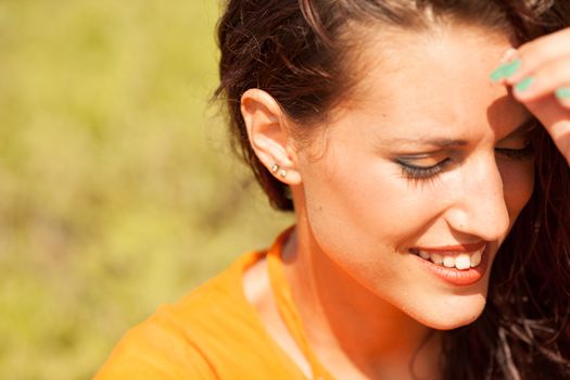 Portrait of young beautiful woman laughing wearing orange shirt