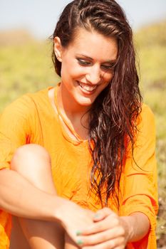 Portrait of young beautiful woman laughing wearing orange shirt