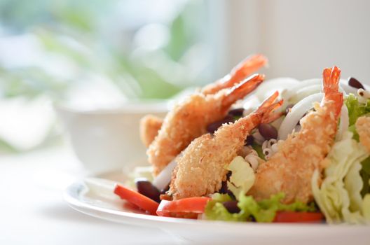 fried shrimp and fresh salad with cream sauce on table