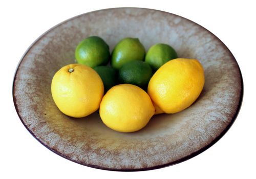 Five limes and three lemons in a clay bowl