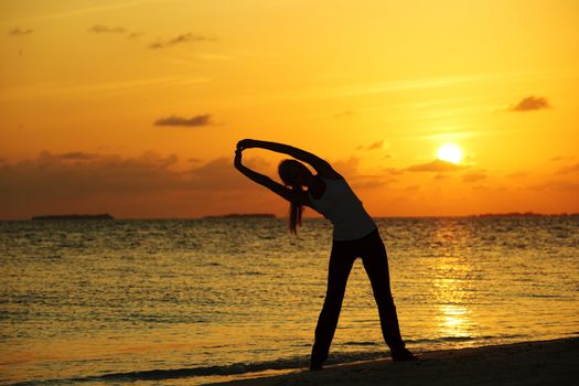 sunset yoga woman on sea coast