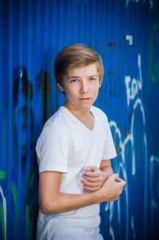 Young smile teenager in front of blue graffiti