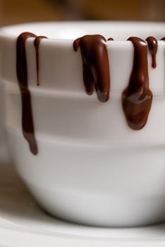 Closeup of White cofee cup with chocolate flowing. Shallow DOF