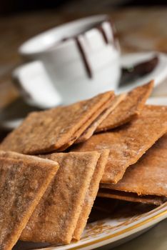 Plate full of cookies and coffe cup with chocolate flowing