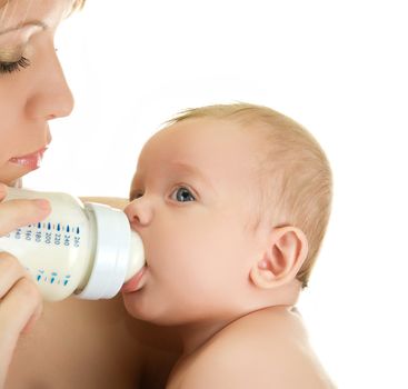 Mother give drink her baby boy by feeding bottle over white