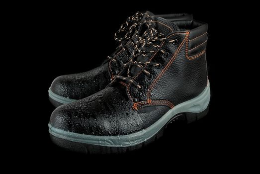 moist modern working boots isolated on a black background