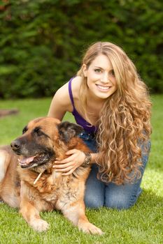 young beautiful woman playing with dog outdoors